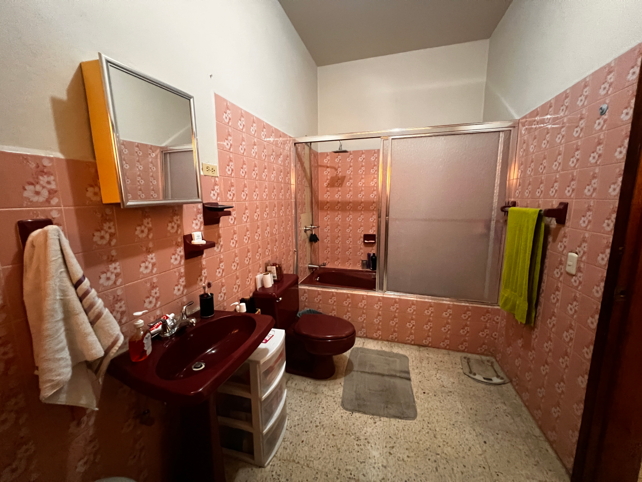 Baño de la habitación principal con su inodoro, lavamanos y tina con puerta de acrílico.