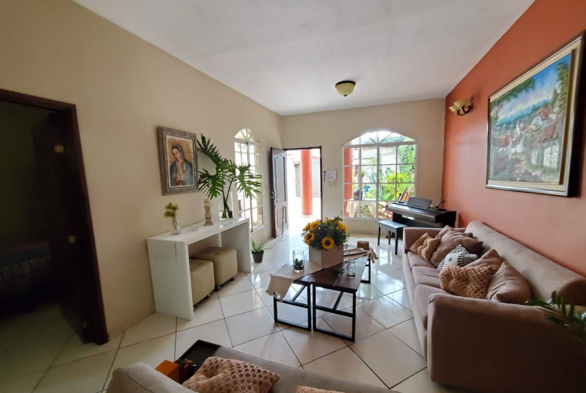 Sala de la casa, con piso de porcelanato, muebles y una puerta con acceso al comedor en Col. Modelo, Tegucigalpa.