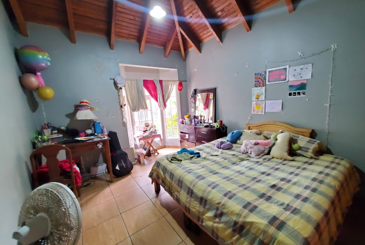 Habitación amplia con una cama matrimonial, un mueble de ropa a un lado con una ventana alta en Col. Modelo, Tegucigalpa.