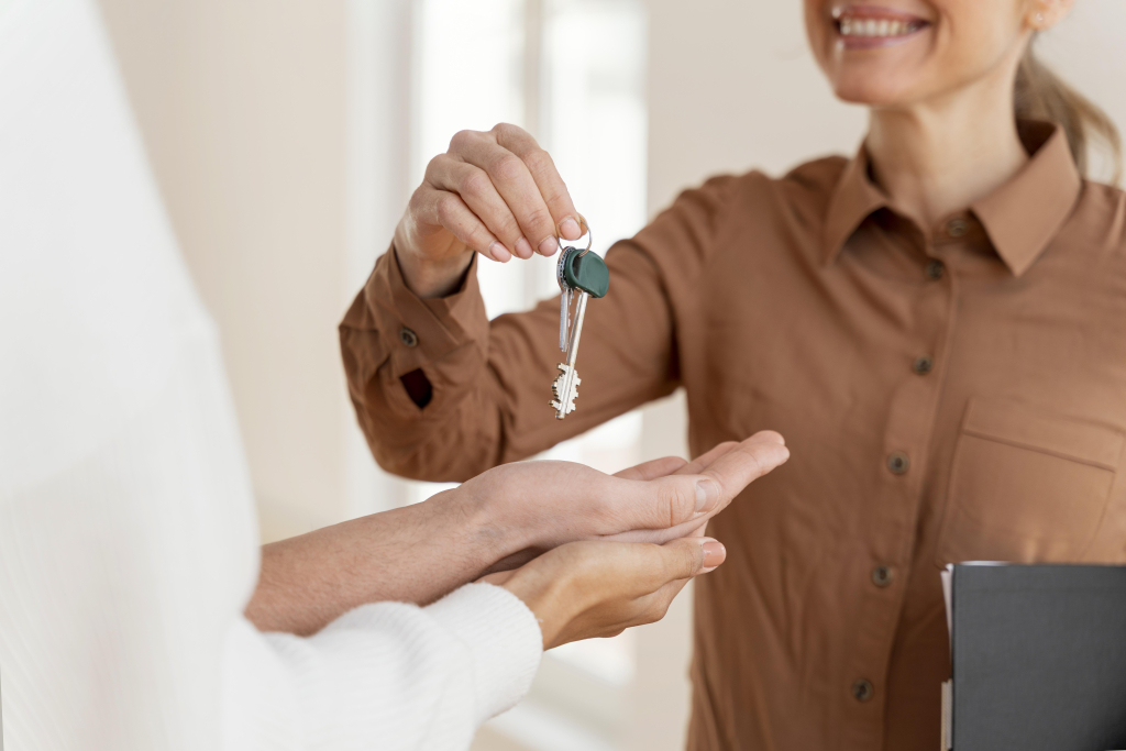 mujer agente bienes raíces entregando pareja llaves de casa