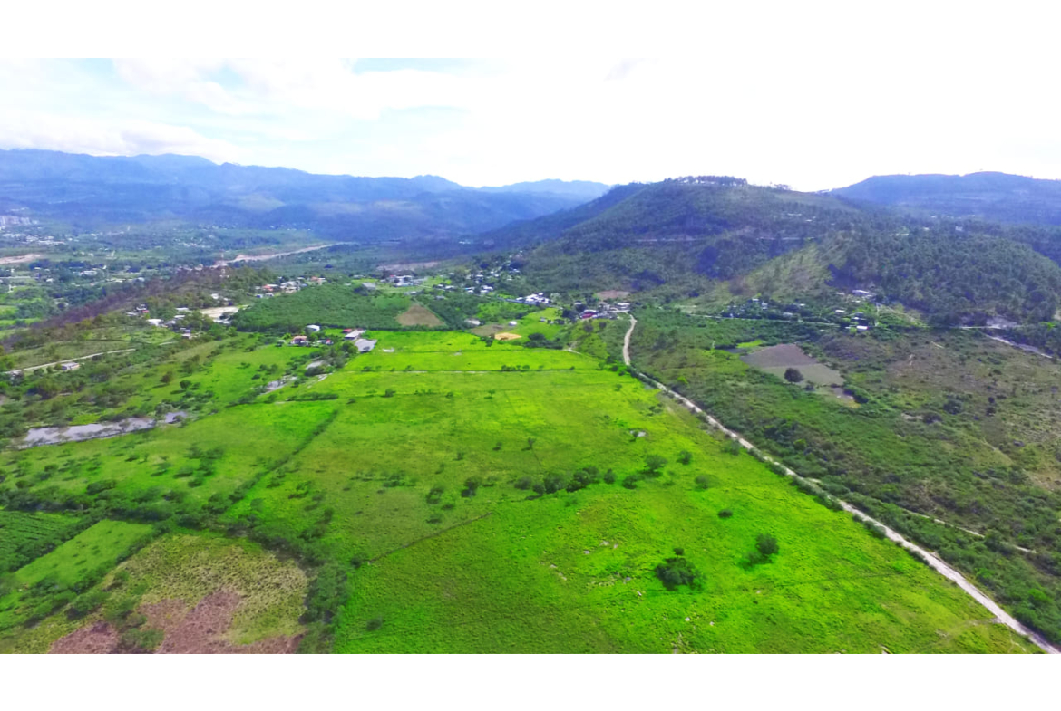Fotografía dron de terreno en Amarateca, Honduras de día bajo el sol con área verde.