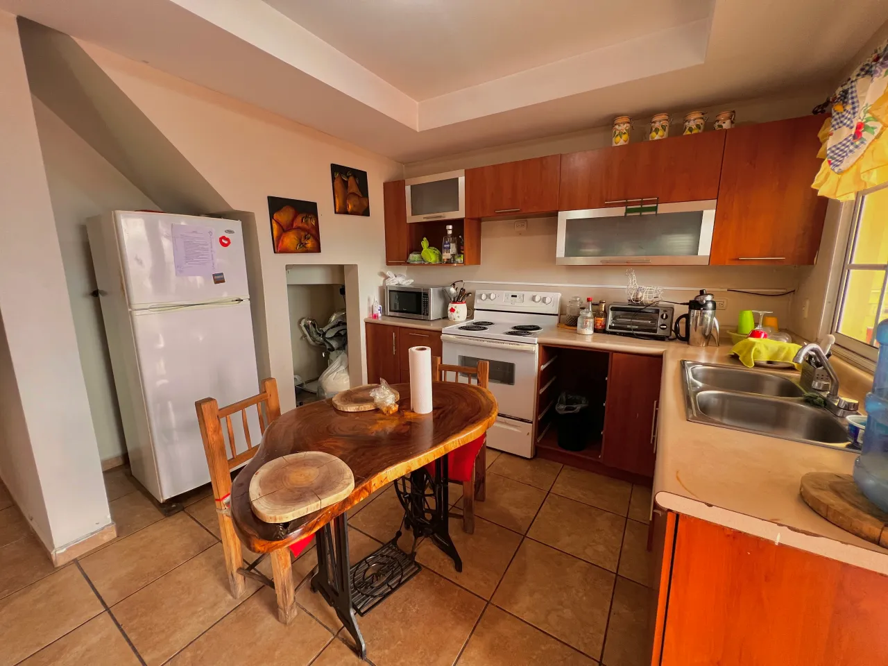 La cocina esta equipada con un mueble de color café con diversos gabinetes para ubicar tus utencilios de cocina.