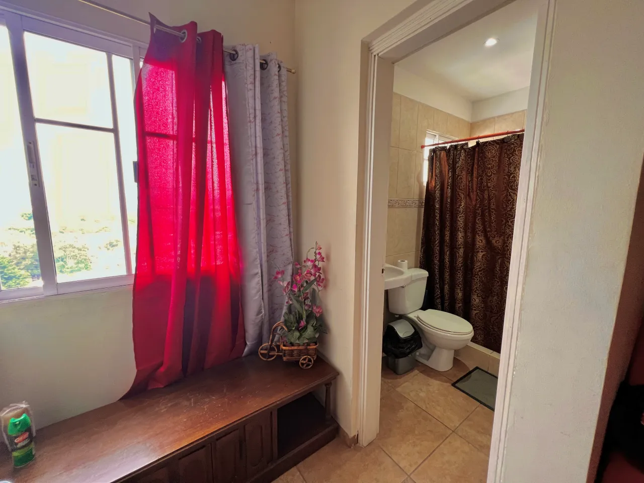 El baño contiene pared de cerámica para darle un toque diferente al resto de la casa, cuenta con ducha, lavamanos y excusado de color blanco.
