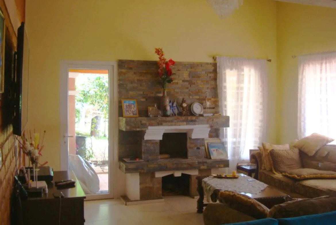 sala de estar cuenta con paredes de color amarillo, chimenea de ladrill, suelo de porcelanato, sillones de color café.