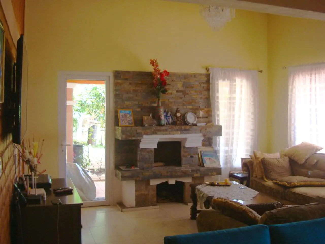 sala de estar cuenta con paredes de color amarillo, chimenea de ladrill, suelo de porcelanato, sillones de color café.