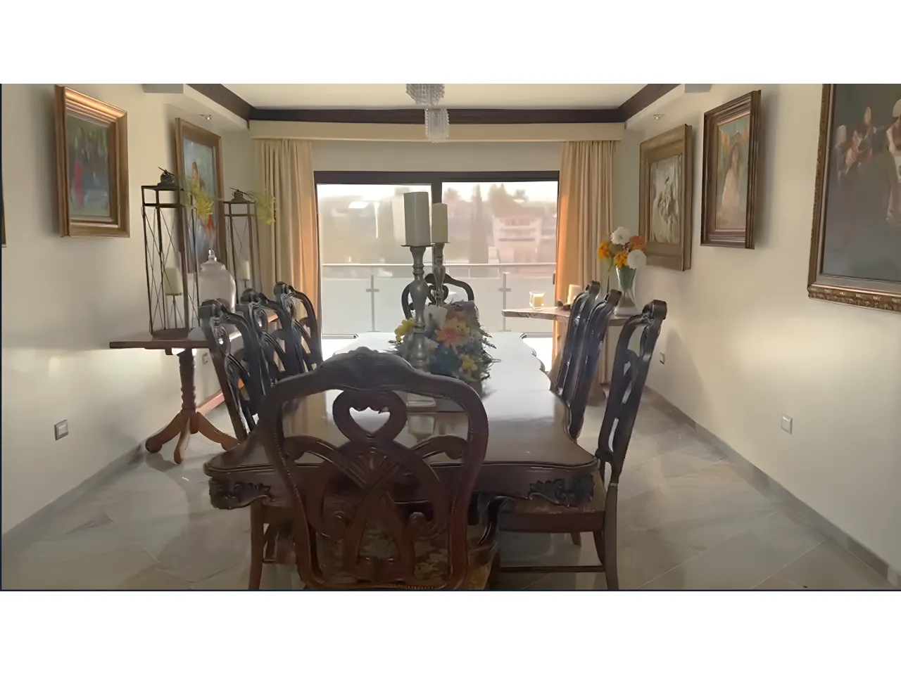 Comedor de la casa en venta, amplio con 8 sillas piso de cerámica de madera, techo color blanco con lámpara colgante y enfrente una puerta corrediza con vista al patio trasero.