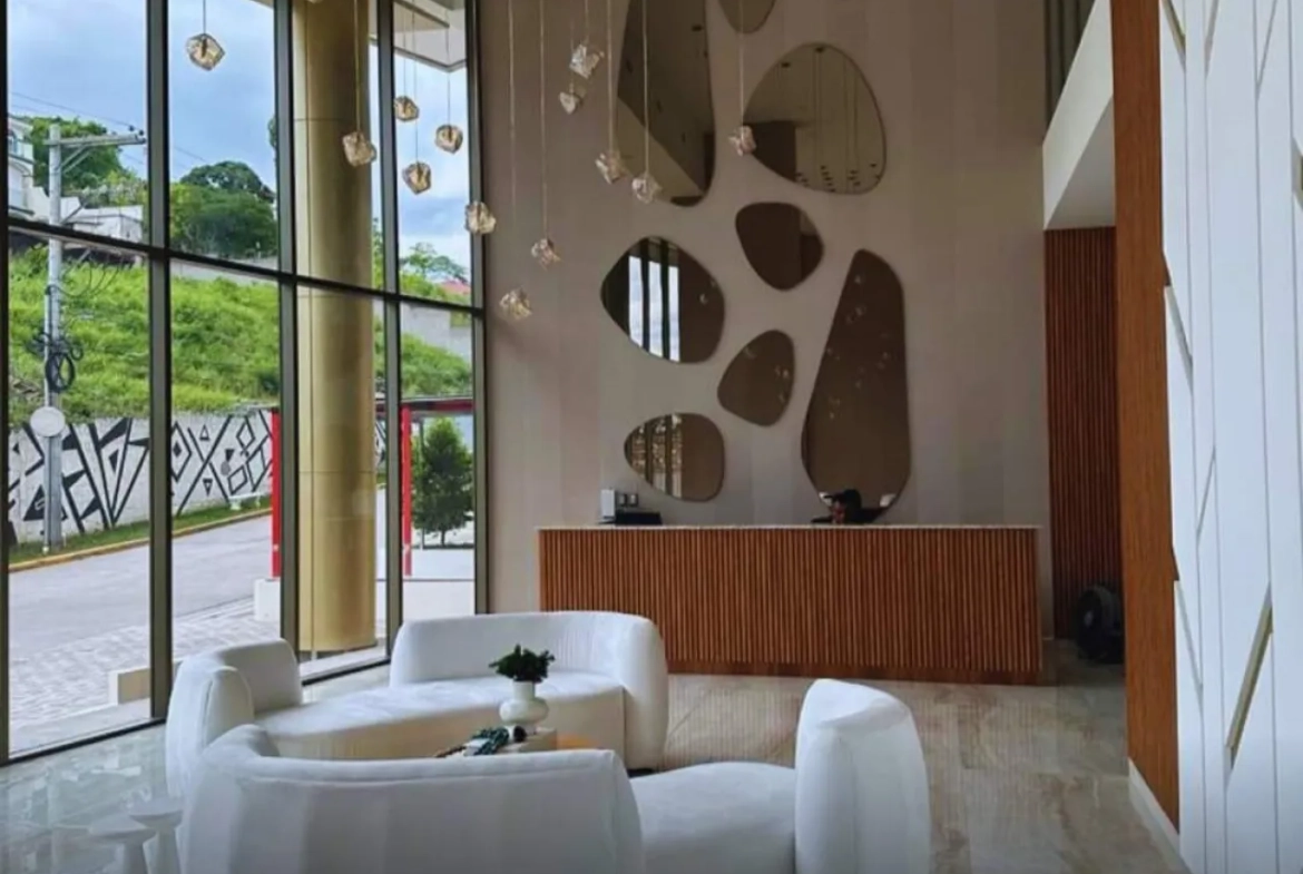 Se renta apartamento en torre ambar, cuenta con una hermosa lobby en donde cuenta con un recibidor, con espejos de fondo, lamparas colgantes, sillones de color blanco.