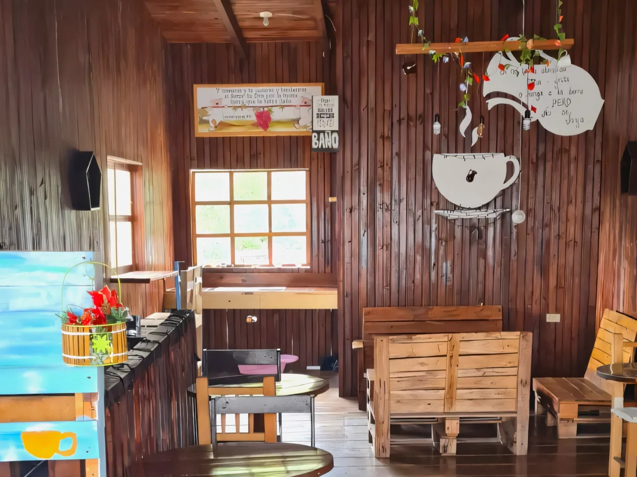 Área para tomar café cuenta con bancas de madera, y un par de ventanas que brindan iluminación natural al interior de la casa.