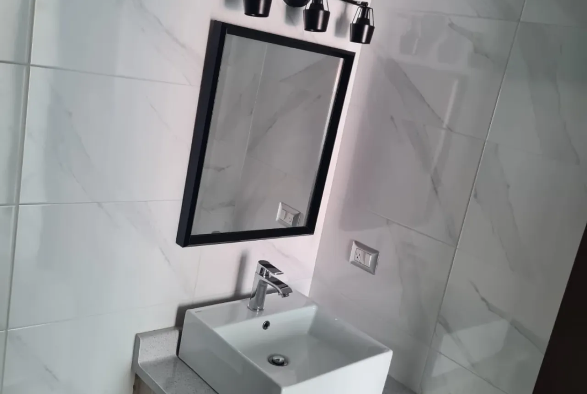 baño enchapado con espejo y mueble de lavamanos aéreo