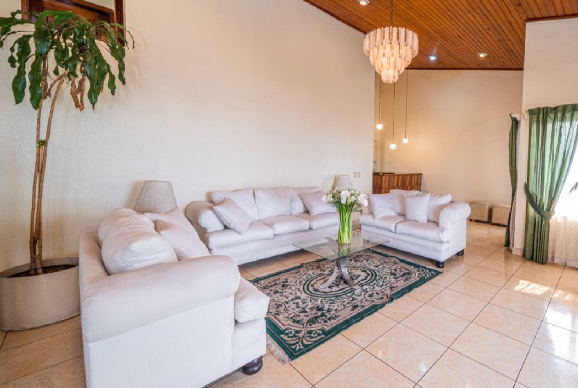 Elegante y cómoda sala para tu familia con excelente iluminacion acompañado de sofas de color blanco y no pueden faltar las plantas que suman color a tu espacio.